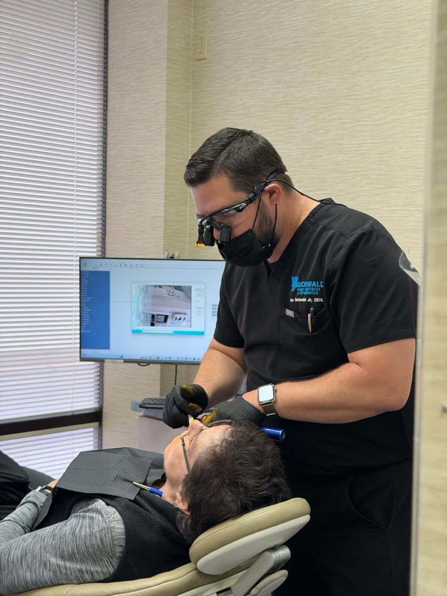 Dr. Buchwald examining a patient while reviewing X-rays at Buchwald Family Dentistry